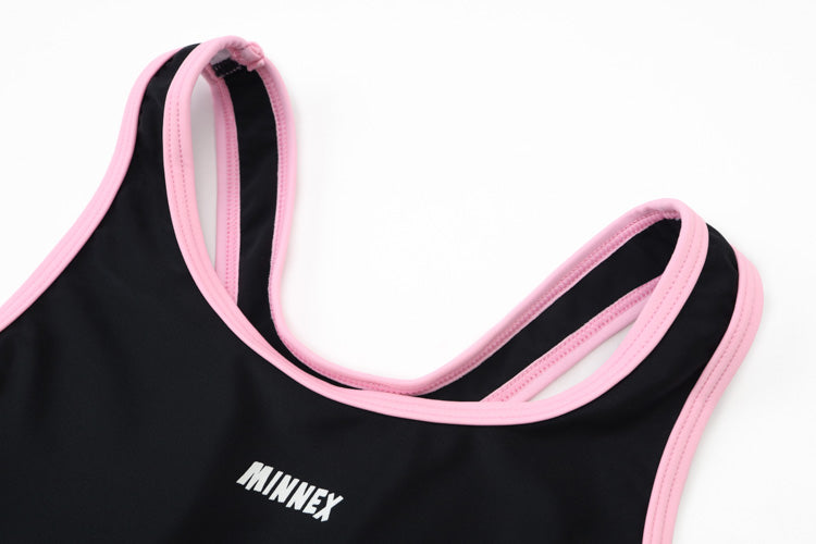 A close-up of the 黑色女童練習泳衣 <68400615-B1>, a black sleeveless girl's swimsuit with pink trim and "MINNEX" in white, highlights its high elasticity and focuses on the upper chest and shoulder straps.