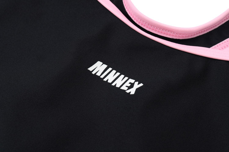Close-up of a 黑色女童練習泳衣 <68400615-B1> with "MINNEX" in white capitals. The high-stretch fabric shows a pink seam along the edge, visible at the top right of the image.