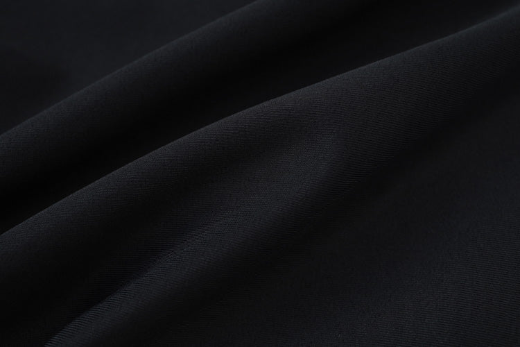 Close-up of the 黑色女童練習泳衣 <68400615-B1> fabric, showing smooth black material with soft folds, a slightly visible weave texture, lightweight feel, and a subtle sheen.