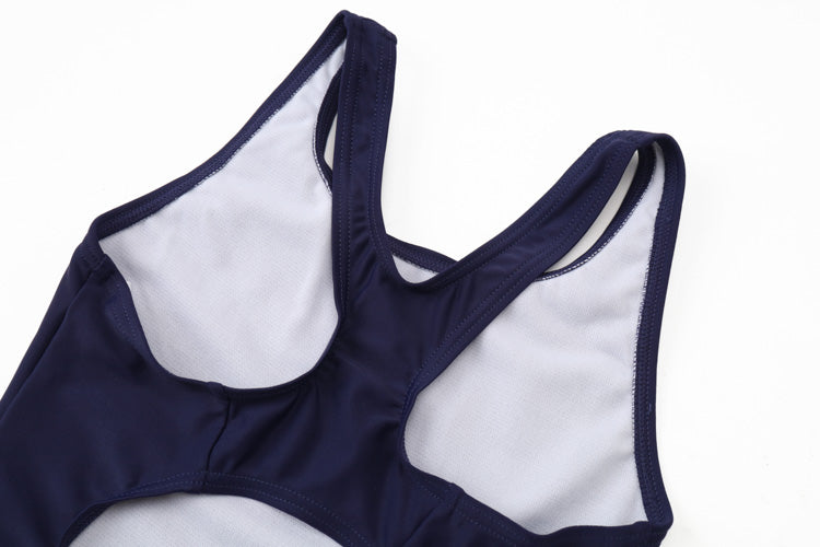 A close-up of the 深藍色女童練習泳衣 <68400616-D1> shows racerback straps, white inner lining, and stitched edges, laid flat on white—perfect for 女童 as a 游泳課專用練習泳衣.