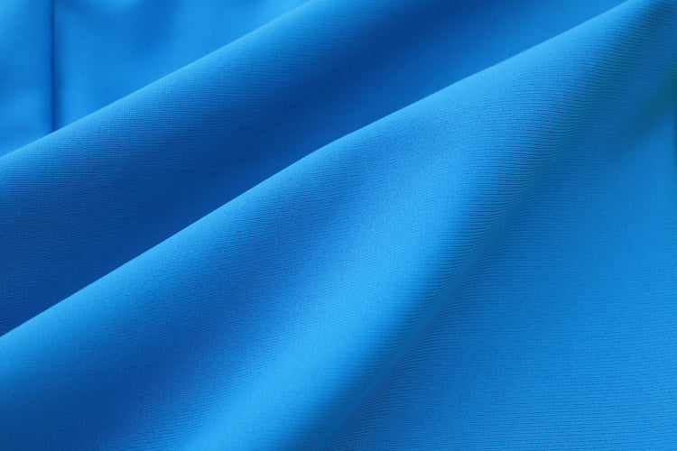A close-up of bright blue fabric with soft folds and a smooth, slightly textured surface, perfect for 藍色及膝童裝防曬褲 <81255-F7> or other 兒童泳裝.