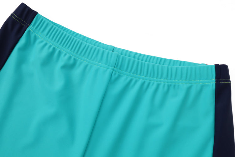Close-up of the waistband of 湖藍及膝童裝防曬褲 <81255-F8> with navy side panels, shown on a white background. The elastic waistband features visible green stitching and is made from high-stretch, UV-protective fabric.
